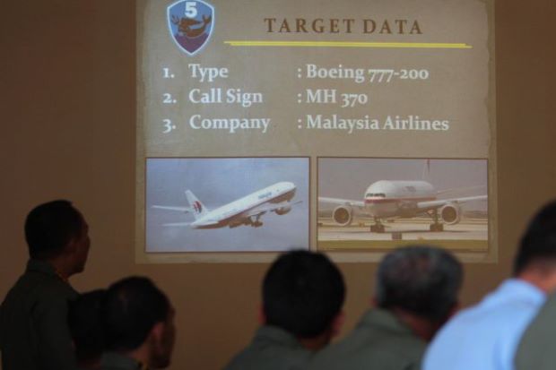 Indonesian Air Force flight crew listen during a briefing at the Medan city military airbase on March 13, 2014 after conducting an aerial search over Malacca Strait.